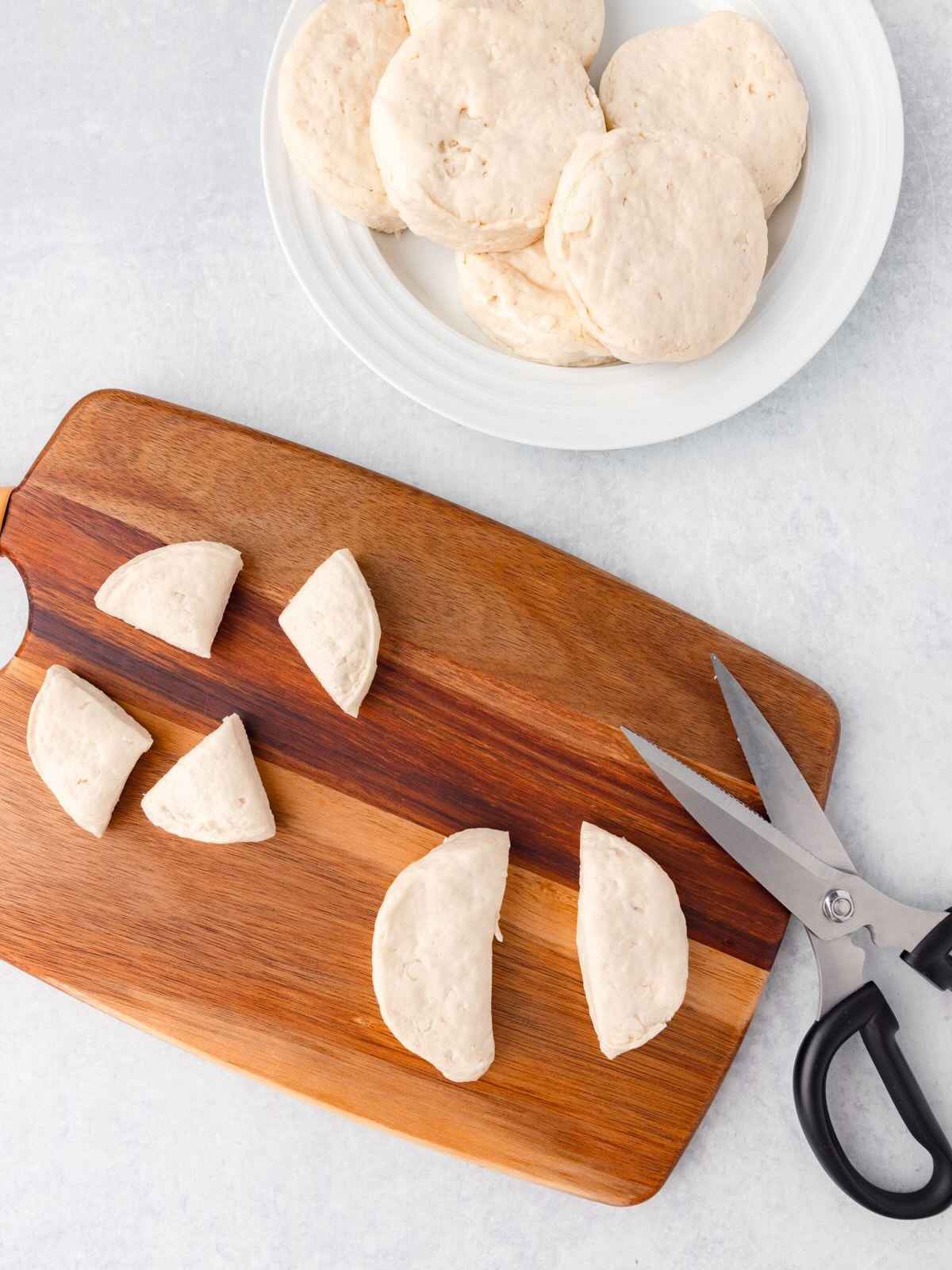 Kitchen scissors cutting up biscuits.