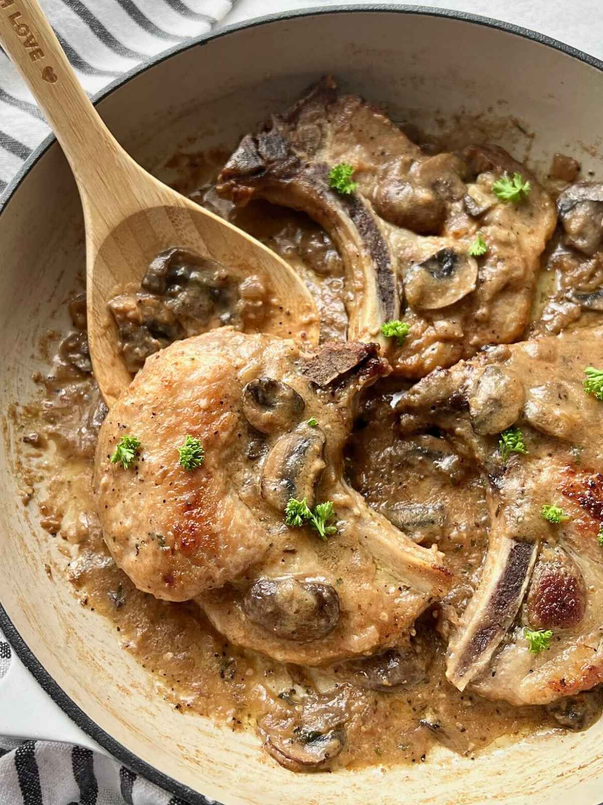 Dutch oven filled with pork chops and mushroom gravy.