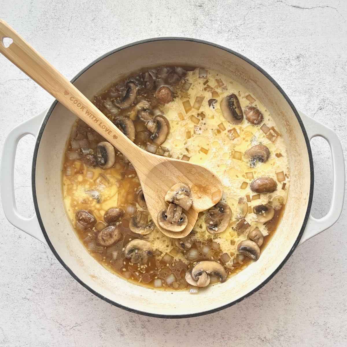 Cream and cornstarch added to mushrooms and onions.