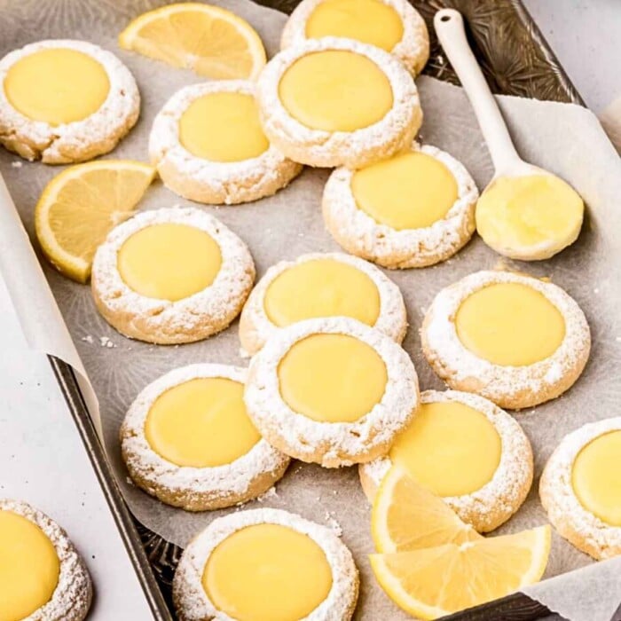Lemon Curd Cookies filled with lemon curd on a sheet pan.