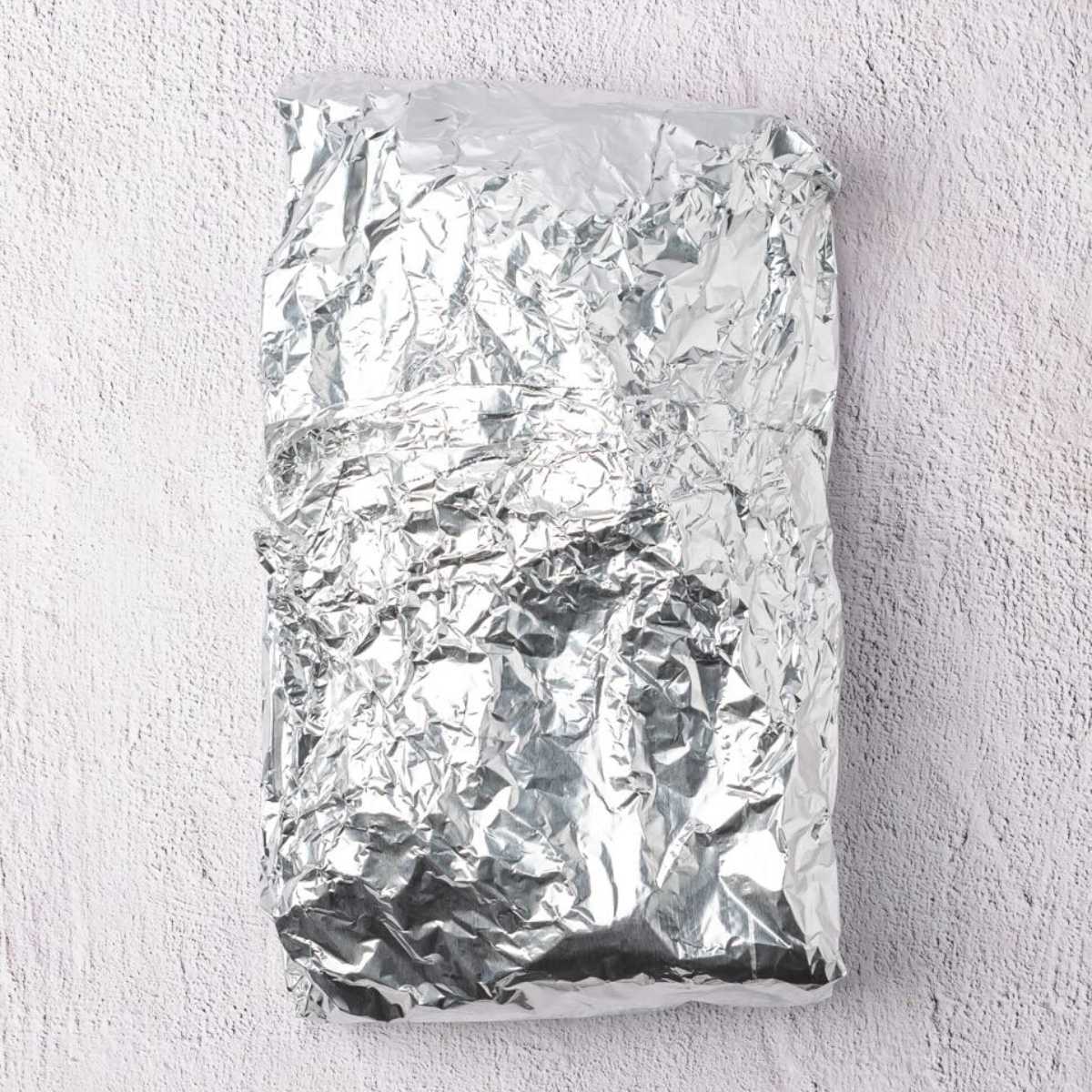 A large rectangular foil packet filled with seafood.