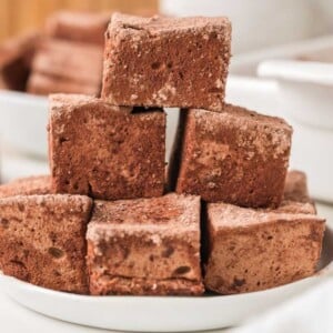 A stack of homemade chocolate marshmallows on a white plate.