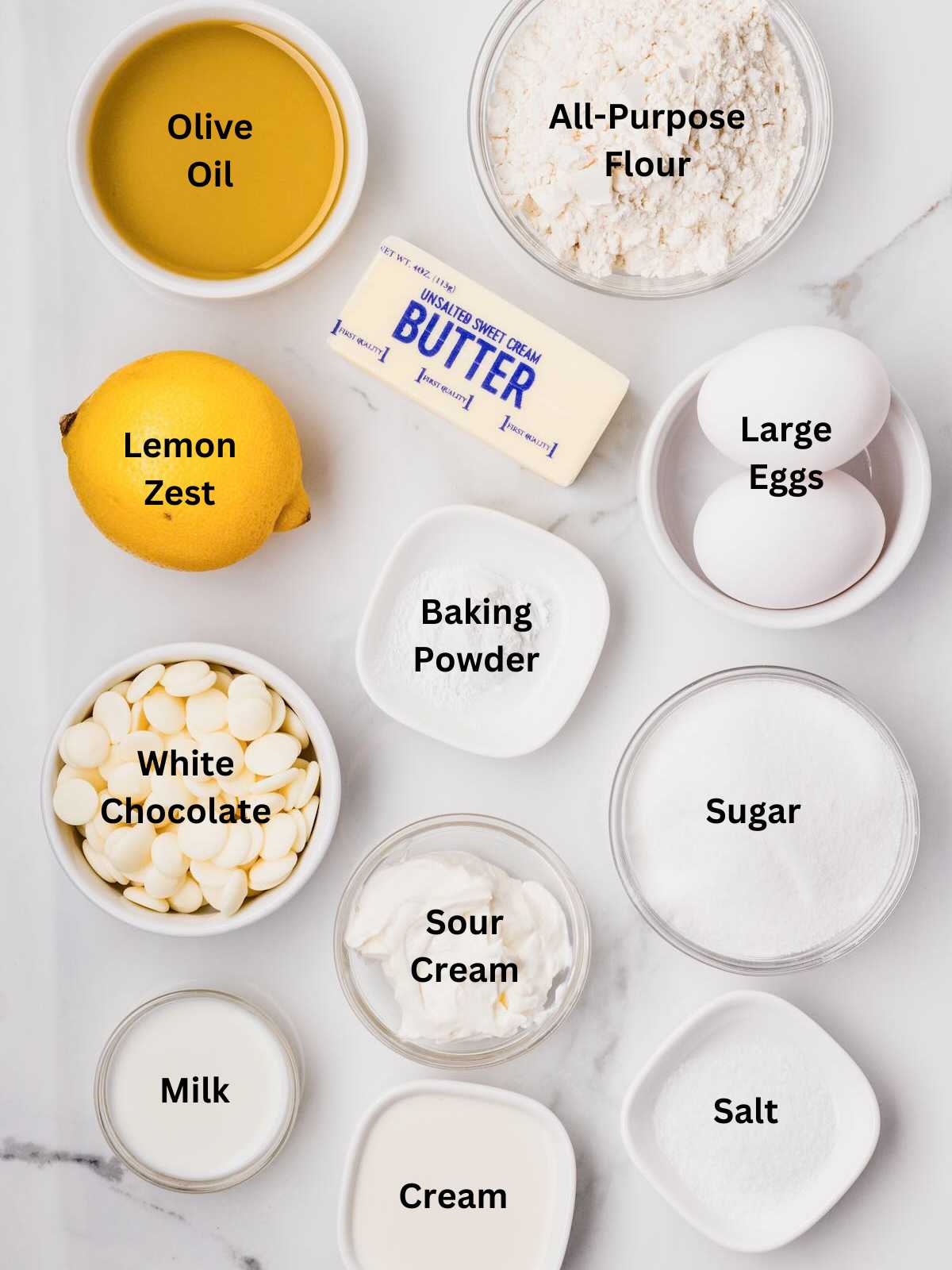 Baking ingredients including flour, eggs, butter, sugar, white chocolate, lemon, oil, milk, cream, and more.