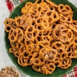 Green plate piled with bite-sized pretzels coated in a brown cinnamon-sugar mixture.